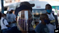 People wear face masks to protect against COVID-19 before boarding a minibus taxi in Johannesburg, Dec. 24,2020.