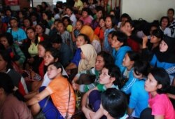 Perempuan dan anak-anak duduk bersama setelah polisi menggerebek sebuah rumah di Bekasi pada 24 Desember 2013. Badan Reserse Kriminal Polri atau 'Bareskrim', menggerebek sebuah rumah di Bekasi dan menemukan perempuan dan anak-anak yang dicurigai diperdaga