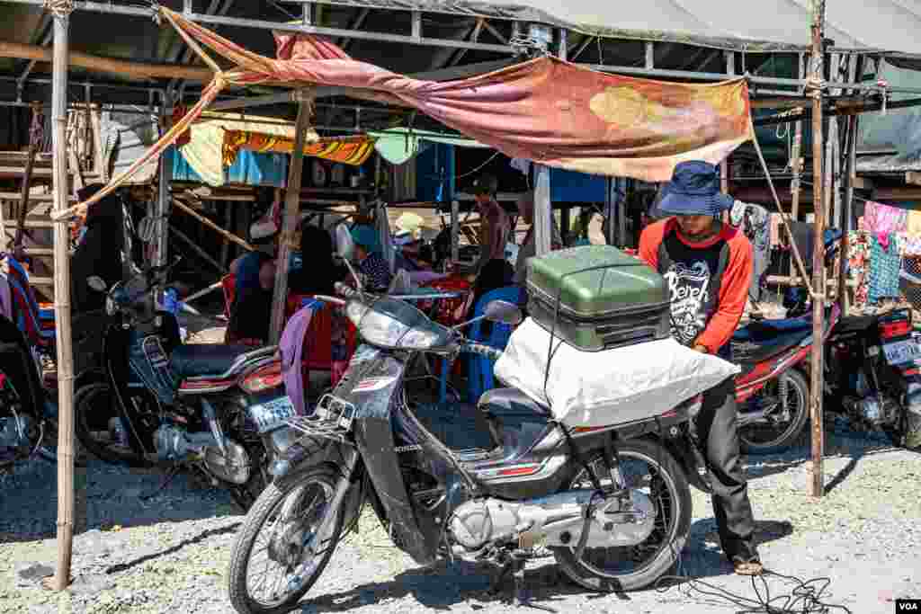បុរសជនជាតិ​ខ្មែរឥស្លាម​​ម្នាក់​ចង​វ៉ាលី​របស់​ខ្លួន​ជាមួយ​នឹង​ម៉ូតូ​បន្ទាប់ពី​រដ្ឋបាល​ខណ្ឌជ្រោយចង្វារ​តម្រូវ​ឲ្យ​ពួកគេ​រុះ​រើសំណង់​រោង​របស់​ខ្លួននៅ​លើ​ច្រាំង​ទន្លេ​សង្កាត់ជ្រោយចង្វារ​ ខណ្ឌជ្រោយចង្វារ​កាលពី​ថ្ងៃទី​៣០ វិច្ឆិកា ឆ្នាំ២០១៩។(ទុំ ម្លិះ/​VOA)