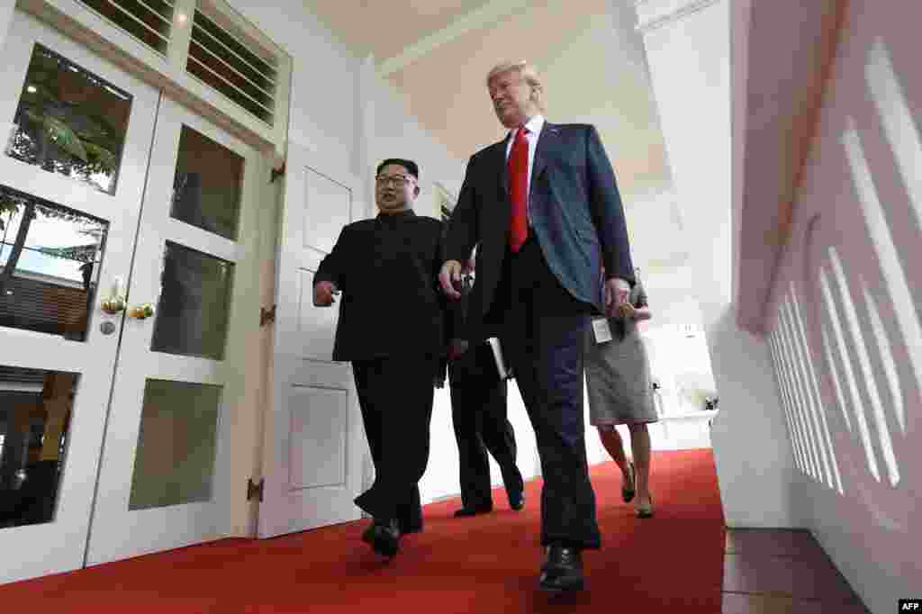 Pemimpin Korea Utara Kim Jong Un (kiri) berjalan bersama Presiden Amerika Serikat Donald Trump (kanan) pada awal acara pertemuan puncak antara Amerika Serikat dan Korea Utara di Hotel Capella di Singapura.(Foto:AFP)