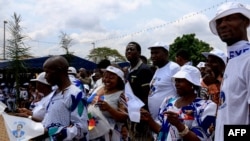FILE - Supporters of Cameroonian President Paul Biya wear clothing emblazoned with his image as they celebrate his re-election in Yaoundé on Nov. 6, 2018.