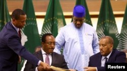 에티오피아 정부 대표 레드완 후세인(좌)과 티그라이 사절 게타추 레다가 2일 남아프리카공화국 수도 프리토리아에서 휴전 합의 문서를 교환하고 있다.