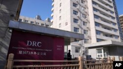 Seorang penjaga keamanan memantau pintu masuk ke kompleks Diplomatik Jianguomen, alamat terakhir Lembaga penyiaran publik Kanada CBC di Beijing, Kamis, 3 November 2022. (AP/Andy Wong)