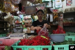 Seorang pedagang cabai mengenakan pelindung wajah untuk mencegah penyebaran wabah virus corona di pasar tradisional Tangerang, Senin, 7 Desember 2020. (Foto: AP)