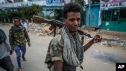 FILE - Fighters loyal to the Tigray People's Liberation Front walk in a town in the Tigray region of northern Ethiopia, May 7, 2021. TPLF fighters say they have taken control of the strategic town of Dessie in Ethiopia's Amhara region.