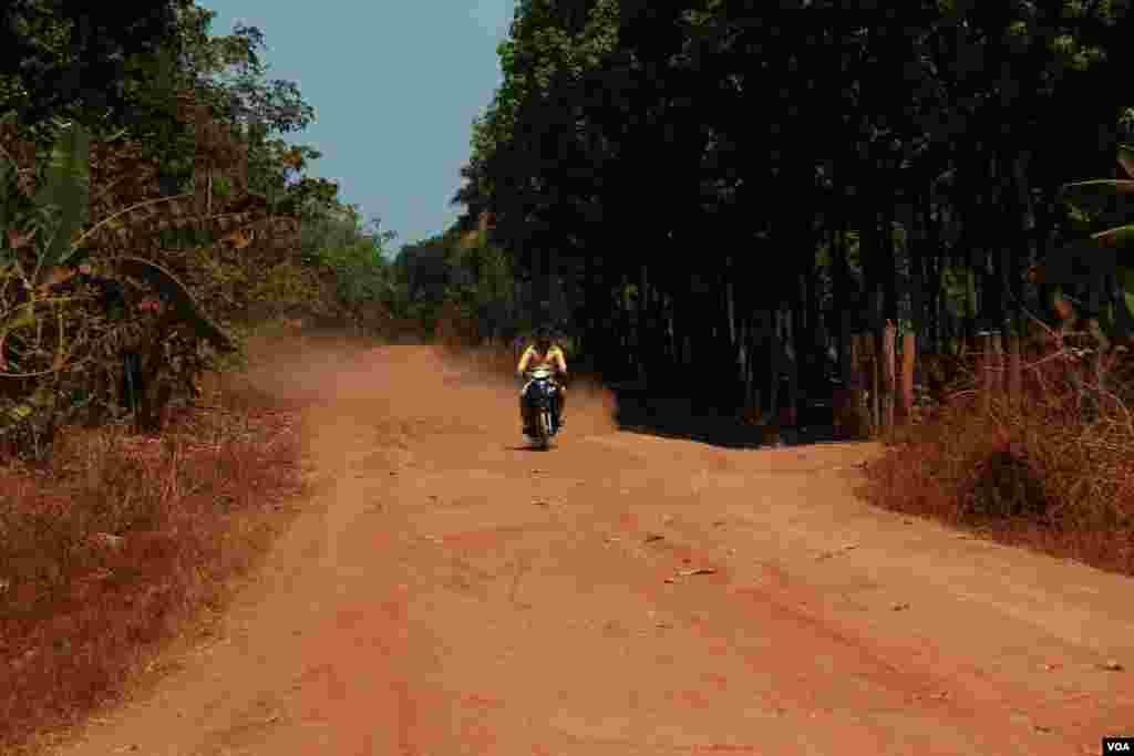 បុរស​ម្នាក់​ជិះ​ម៉ូតូ​លើ​ផ្លូវ​ដី​ក្រហម​មួយ​ ក្នុង​ស្រុក​ពេជ្រាដា​ ក្នុង​ខេត្ត​មណ្ឌល​គិរី ​ថ្ងៃ​ទី១០​ ខែ​មីនា ឆ្នាំ​២០១៥។ &nbsp;