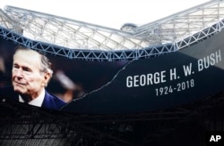 Na stadionu u Atlanti, pred NFL utakmicu domaćih Falkonsa i gostujućih Baltimor Rejvensa ukazana je počast bivšem američkom predsedniku Džordžu Bušu starijem.