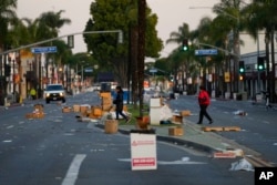 Warga berjalan melintasi lokasi festival Tahun Baru Imlek setelah dibatalkan karena penembakan massal di dekat Monterey Park, California, Minggu, 22 Januari 2023. (AP/Jae C. Hong)