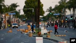 Warga berjalan melintasi lokasi festival Tahun Baru Imlek setelah dibatalkan karena insiden penembakan massal di dekat Monterey Park, California, Minggu, 22 Januari 2023. (AP/Jae C. Hong)