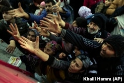 Volunteers distribute aid to people in Antakya, southern Turkey, Wednesday, Feb. 8, 2023. (AP Photo/Khalil Hamra)