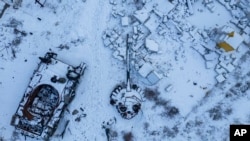 Uništeni ruski tenk, prekriven snijegom, stoji u dvorištu privatne kuće u gradu Sviatohirsk, Ukrajina, 12. veljače 2023.