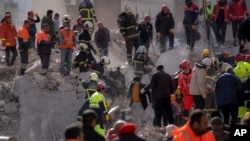 Firefighters and rescue personnel search for survivors in the rubble of a destroyed building in Adana, southern Turkey, Feb. 8, 2023.