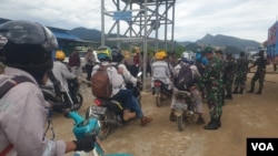 Personel TNI-POLRI melakukan pemeriksaan terhadap pekerja yang hendak memasuki pabrik smelter PT GNI di Morowali Utara, Sulawesi Tengah, 19 Januari 2023 menyusul terjadinya bentrok antara pekerja Indonesia dan China. (Foto : VOA/Yoanes Litha)