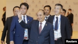 Vietnam's President Nguyen Xuan Phuc (C) waves as he arrive to attend the 29th APEC Economic Leaders' Meeting (AELM) during the APEC 2022 summit in Bangkok, Thailand, 18 November 2022. Thailand hosts the Asia-Pacific Economic Cooperation or APEC 2022, the summit for economic cooperation comprising 21 leading member economies to promote free trade in the Asia-Pacific region.Diego Azubel/Pool via REUTERS