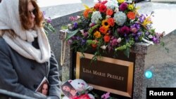 Seorang pelayat melewati lokasi pemakaman Lisa Marie Presley, di Graceland, Memphis, Tennessee, Minggu 22 Januari 2023.