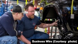A student from McPherson College works restoring a Ford Bronco during a summer internship.