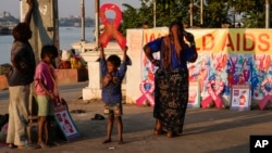 Anak-anak jalanan di Kolkata, India bermain dengan pita merah yang dipajang oleh para aktivis di tepi Sungai Hooghly menjelang Hari AIDS Sedunia tahun lalu (foto: dok). 