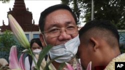 Thach Setha, vice president of the country's main opposition Candlelight Party, hugs a boy in front of the Prey Sar main prison outside Phnom Penh, Cambodia, on November 10, 2021. (Heng Sinith/AP)