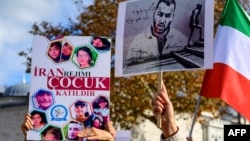 FILE - People hold portraits of Iranian rapper Toomaj Salehi, right, and children, left, who were killed during the protests in Iran, during a rally in Istanbul, Turkey, on Nov. 26, 2022. 