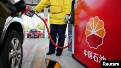 FILE: Seorang petugas mengisi bensin ke mobil pelanggan di pompa bensin PetroChina di Nantong, provinsi Jiangsu, China, 28 Maret 2018. (Stringer/REUTERS)