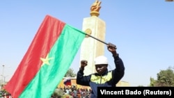 ARCHIVES - Un homme tient le drapeau du Burkina Faso à Ouagadougou, le 25 janvier 2022.
