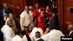 Opposition Economic Freedom Fighters party members react after they were removed from the national assembly during South African President Cyril Ramaphosa's State of the Nation address at parliament in Cape Town, South Africa, Feb. 9, 2023.