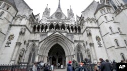 FILE - Media wait outside the High Court in London, on March 18, 2021. 