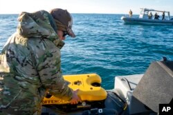 FILE - Sailors assigned to an ordnance disposal group prepare an underwater vehicle to search for debris from a Chinese high-altitude balloon off the coast of Myrtle Beach, S.C., Feb. 7, 2023. (Ryan Seelbach/U.S. Navy via AP)