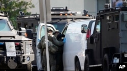 Pripadnici specijalnih policijskih snaga pretražuju kombi u kojem je pronađeno telo osumnjičeng za masovno ubistvo u Monterej Parku u Kaliforniji (Foto: AP/Damian Dovarganes)