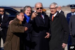 ປະທານາທິບໍດີສະຫະລັດ ທ່ານໂຈ ໄບ​ເດັນຄ່າຍ​ຮູບ​ແບບ​ແຊ​ລ​ຟີ ຮ່ວມ​ກັບທ່ານ Tony Evers, ຜູ້​ປົກ​ຄອງ​ລັດ​ວິ​ສ​ຄອນ​ຊິນ (ຂວາ) ຫຼັງ​ຈາກ​ໄປ​ເຖິງສະ​ໜາມ​ບິນຖານ​ທັບ​ພິ​ທັກທາງ​ອາ​ກາດ Truax Field Air National Guard Base, ວັນ​ທີ 8 ກຸມ​ພາ, 2023, ໃນ​ເມືອງ​ເມ​ດິ​ສັນ, ລັດ​ວິ​ສ​ຄອນ​ຊິນ.