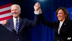 President Joe Biden and Vice President Kamala Harris stand on stage at the Democratic National Committee winter meeting, Feb. 3, 2023, in Philadelphia. 
