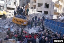 Syrian President Bashar al-Assad and his wife Asma al-Assad inspect rescue operations at the site of damaged buildings, in the aftermath of the earthquake, in Jableh , Syria, in this handout released by SANA on February 11, 2023.