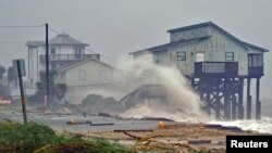 Waves crash on stilt houses along the shore as Hurricane Michael's power is unleashed in Alligator Point, Franklin County, Fla., Oct. 10, 2018.