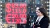 Orang-orang berjalan melewati layar yang menunjukkan nilai tukar mata uang dolar Amerika dan Euro terhadap rubel Rusia di Moskow, pada 28 Februari 2022. (Foto: Ap/Pavel Golovkin)