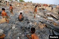 FILE - Boys search for useful items among the ashes of burnt houses after fire destroyed shelters at a camp for internally displaced Rohingya Muslims in the western Rakhine State near Sittwe, Myanmar, May 3, 2016.