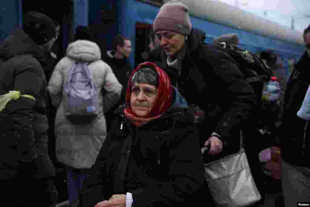 A woman on a wheelchair waits to board a train during snowfall, as civilians flee Russia&#39;s invasion of Ukraine, in Odessa, March 8, 2022.