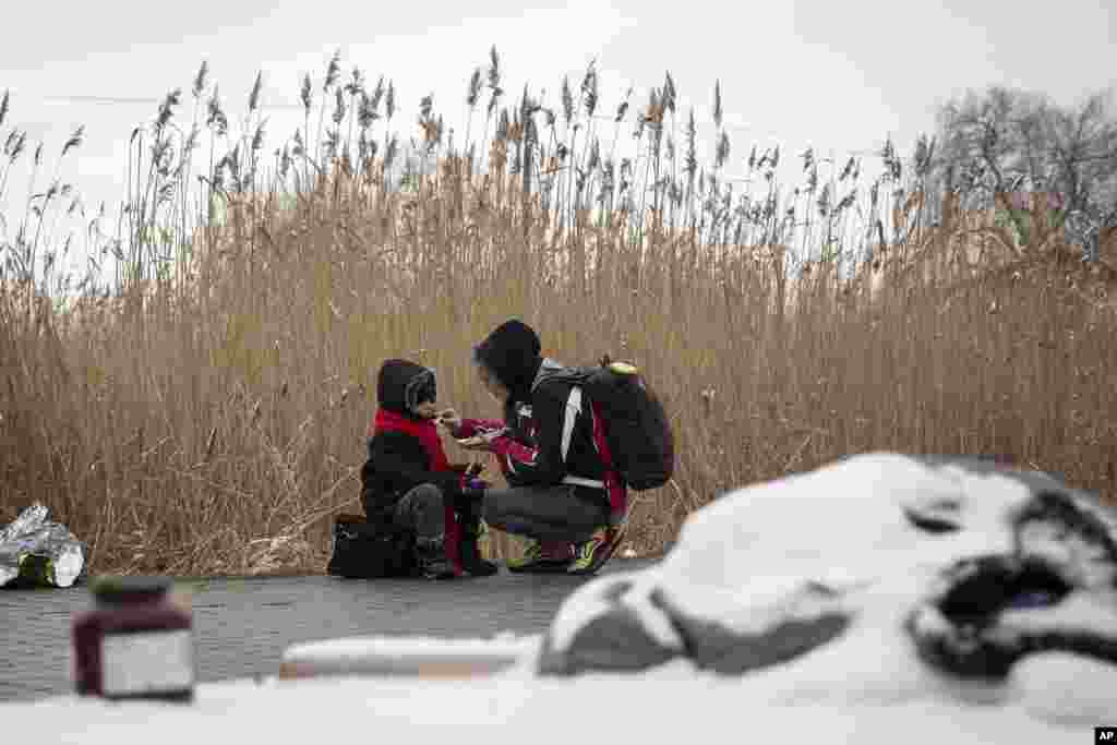 Tatiana Kostyuk, 38, from Zaporozhye, feeds her child at the border crossing in Medyka, Poland, March 9, 2022.