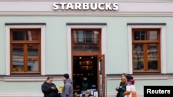 Sejumlah orang tampak mengantre pesanan mereka di luar kedai kopi Starbucks di Moskow, Rusia, pada 29 Oktober 2021. (Foto: Reuters/Evgenia Novozhenina)
