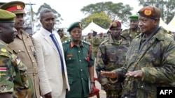 Président ya Uganda Yoweri Museveni (G), pene na mwa na ye gén. Muhoozi Kainerugaba (D2) azo'solola na bakambi ya mampinga ma Sudan ya Sud, Kenya, Somalie mpe Tanzanie na Mbende, na west ya Kampala, 6 septembre 2014.