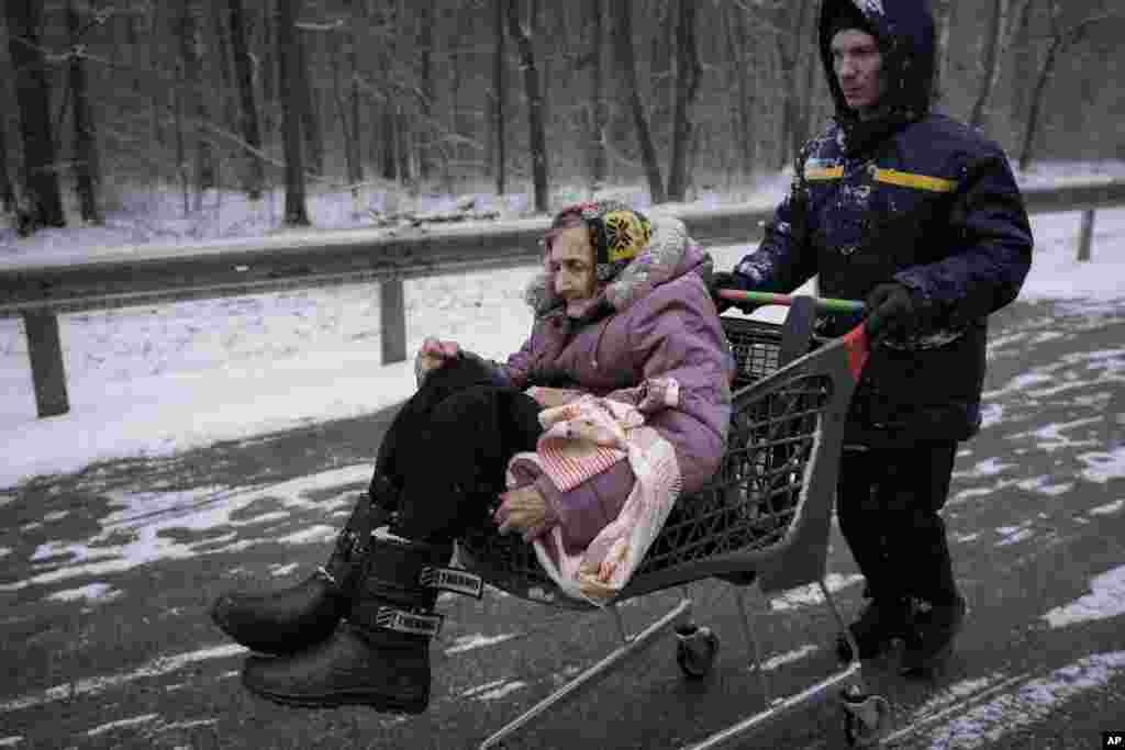 An elderly lady is carried in a shopping cart after being evacuated from Irpin, March 8, 2022.