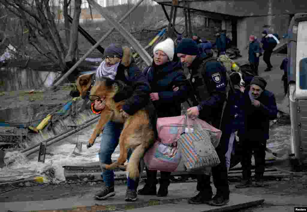 A man carries a dog as people flee, amid Russia&#39;s invasion of Ukraine, in Irpin, Ukraine, March 9, 2022.