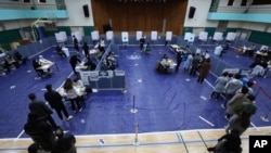 People wait in line to cast their votes for the presidential election at a polling station in Seoul, South Korea, March 9, 2022.