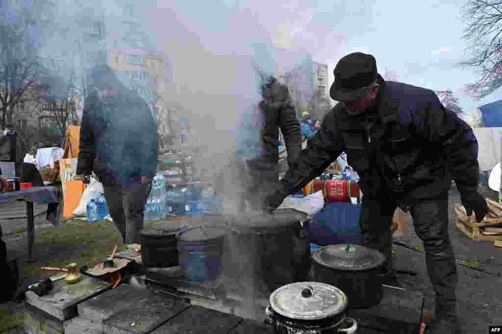 Local residents and volunteers prepare some food for Ukrainian servicemen and members of Ukrainian territorial defense outside an apartment building on Kyiv outskirts, March 6, 2022.