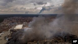 Sebuah pabrik dan toko terbakar setelah dibombardir pasukan Rusia di Irpin, di pinggiran Kyiv, Ukraina, Minggu, 6 Maret 2022. (Foto: AP/Emilio Morenatti)