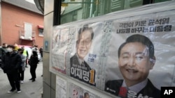 Posters of presidential candidates of Lee Jae-myung of the ruling Democratic Party and Yoon Suk Yeol, right, of the main opposition People Power Party are displayed as people wait to cast their early votes for the March 9 presidential election, Seoul, March 4, 2022.