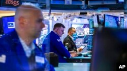 Para pedagang saham tampak bekerja di kantor Bursa Saham New York pada 7 Maret 2022. (Foto: New York Stock Exchange via AP/Courtney Crow)