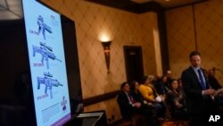 Images of an AR-15-style rifle are displayed at a news conference in Trumbull, Connecticut, Feb. 15, 2022. The families of nine victims of the Sandy Hook Elementary School shooting have agreed to a $73 million settlement of a lawsuit against the maker of 