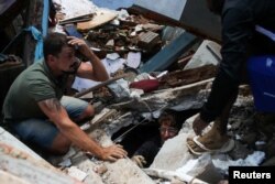 Men look for bodies at a mudslide at Morro da Oficina after pouring rains in Petropolis, Brazil, Feb. 16, 2022.