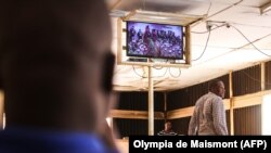 Des Burkinabè regardent la télévision à Ouagadougou, le 19 février 2022.