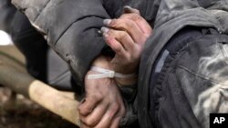 Seorang warga sipil yang tewas dengan tangan terikat di belakang terbaring di tanah di Bucha dekat Kyiv, Ukraina, Senin 4 April 2022. (AP/Efrem Lukatsky)